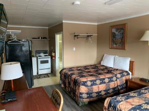 a hotel room with two beds and a kitchen at Village Inn & Suites - Sudbury in Lively
