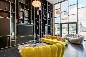 a living room with a yellow couch and a tv at Best Western Plus Europe Hôtel Brest in Brest