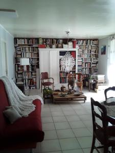 a living room with a lot of bookshelves at La Maison d'Alruna in Beauchalot