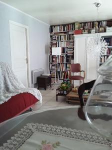 a living room with a bed and a room with books at La maison d'Alruna in Beauchalot