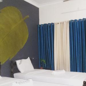 Habitación con 2 camas y cortinas azules. en Oceanic Beach Residency, en Varkala