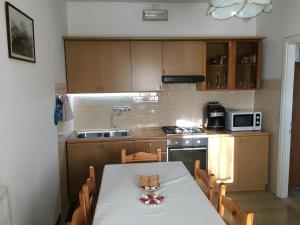 cocina con mesa con sillas y microondas en Appartamento da Cristina, en Conco