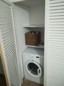 eine Waschmaschine und einen Trockner in einem Zimmer mit einem Schrank in der Unterkunft Il Ficupala, Pozzallo Sea House in Pozzallo