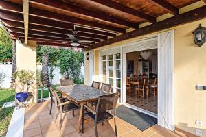 un patio con mesa y sillas en un porche en Villa los Alamos, en Aguadulce