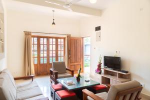 a living room with a table and chairs and a tv at Casa Arvana Near Calangute Beach in Calangute