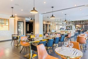 a restaurant with tables and chairs and a bar at Best Western Plus Europe Hôtel Brest in Brest