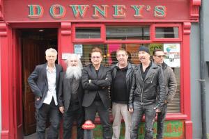 a group of men standing in front of a red building at Junior Suite Town Centre in Dungarvan