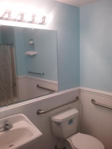 a bathroom with a toilet and a sink and a mirror at Apollo Motel in Wildwood Crest