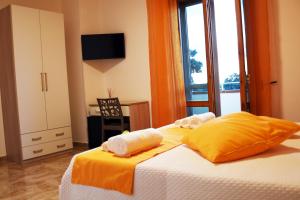 1 dormitorio con 1 cama con sábanas amarillas y ventana en La Pescarella en Ginosa