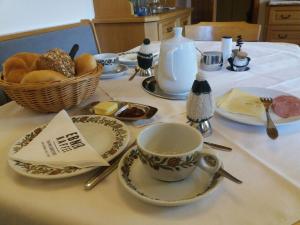 - une table avec une tasse et des assiettes de nourriture dans l'établissement Haus Christoph, à Abersee