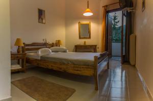 a bedroom with a bed, desk and a lamp at Neos Omalos Hotel in Omalos