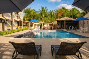 a pool at a resort with chairs and umbrellas at Hotel Amendoeiras in Prado