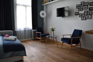 ナウェンチュフにあるAtelier Foto Lipowa - Apartamentyのベッドルーム1室(椅子2脚、テーブル、テレビ付)