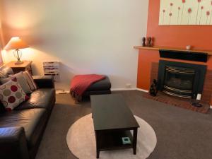 a living room with a couch and a fireplace at Oats Cottage in Hahndorf