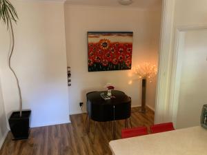 a dining room with a table and a painting on the wall at Oats Cottage in Hahndorf