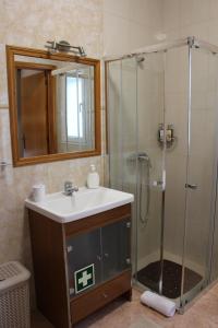 a bathroom with a sink and a shower with a mirror at Cantinho da Luz in Ponta Delgada +60 photos