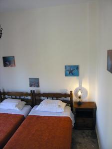 a bedroom with two beds and a table with a lamp at Popy Apartments in Ierapetra