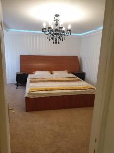 a bedroom with a large bed and a chandelier at CHALET Craiova in Craiova