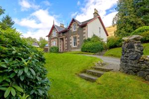 una casa vieja con un camino de piedra que conduce a ella en Mansefield House en Arrochar