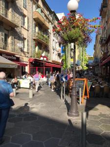 a group of people walking down a city street at chez Eva in Nice