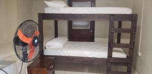 un paio di letti a castello con ventilatore in camera di Roseau Hostel & Beach Front Property a Roseau