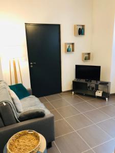 a living room with a couch and a flat screen tv at NOUVEAU : Le puits de Sarlat in Sarlat-la-Canéda +4 photos