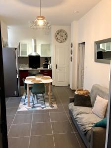 a kitchen and living room with a table and a couch at NOUVEAU : Le puits de Sarlat in Sarlat-la-Canéda