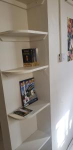 una estantería blanca con libros en una nevera en Roseau Hostel & Beach Front Property en Roseau