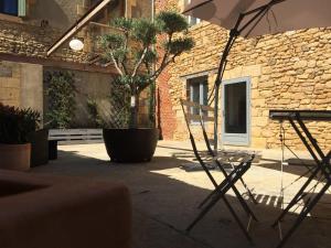 una silla y un banco en un patio con un edificio en NOUVEAU : Le puits de Sarlat, en Sarlat-la-Canéda