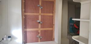 a pair of wooden doors in a closet at Roseau Hostel & Beach Front Property in Roseau