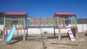 un parque infantil con una estructura de juego colorida y un tobogán en Villas La Quinta, en Creel