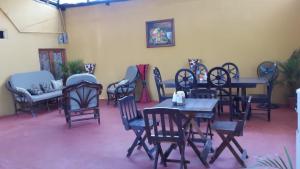 um grupo de cadeiras e mesas num quarto em Hostal Nathaly em Moyogalpa