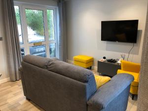 a living room with a couch and a flat screen tv at The Annexe in Teignmouth