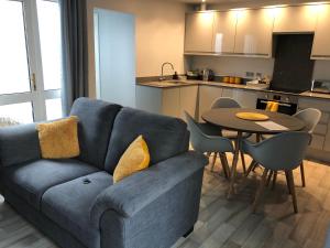 a living room with a blue couch and a table at The Annexe in Teignmouth