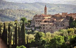 a village on a hill with trees and a church at La casa di Elvira in San Gusmè