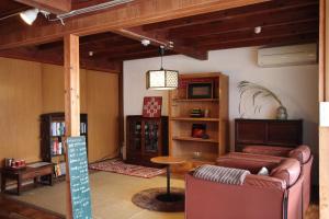 salon z kanapą i stołem w obiekcie Little Bird Inn 旧Minato Guesthouse w mieście Sakaiminato