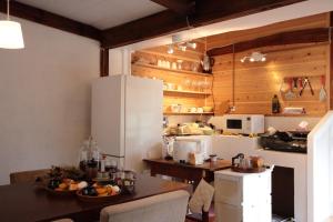 cocina con mesa y nevera blanca en Little Bird Inn 旧Minato Guesthouse en Sakaiminato