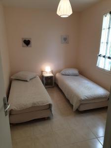 - une chambre avec deux lits, une lampe et une fenêtre dans l'établissement LE CLOS VARNAY, à Meusnes