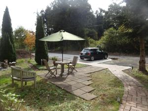 a table and chairs with an umbrella and a car at Gasthof Arutany in Nasu