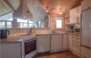 a kitchen with white cabinets and a stove top oven at Awesome Home In Rudkøbing With Sauna in Spodsbjerg