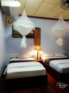 a room with two beds and a lamp in it at Anouxa Riverview Guesthouse in Champasak