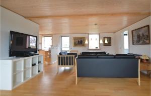 sala de estar con sofá y TV de pantalla plana en Cozy Home In Thyholm With Kitchen, en Thyholm