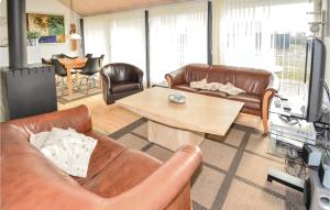 a living room with leather furniture and a table at Nice Home In Brovst With Sauna in Brovst