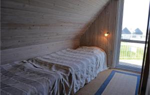 VestervigにあるNice Home In Vestervig With 4 Bedroomsの窓付きの木造の部屋のベッド1台