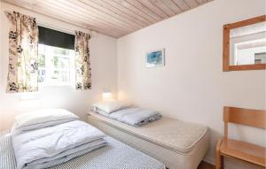 アリンエにあるSkagenhuset Lejl, 1の白い壁の客室で、ベッド2台、窓が備わります。