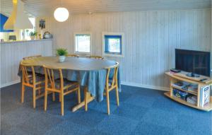 a dining room with a table and chairs and a tv at Holiday Home Sommerbyen Nyborg Ii in Nyborg