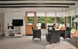 ボーゲンセにあるBeautiful Home In Bogense With Kitchenのリビングルーム(テーブル、椅子、テレビ付)
