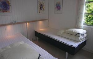 a bedroom with two beds and a window at Sorbus in Rønne +3 photos