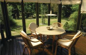 a table and chairs on a porch with windows at Sorbus in Rønne