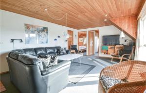 sala de estar con sofá de cuero y mesa en Amazing Home In Fan With 5 Bedrooms, Sauna And Wifi, en Fanø